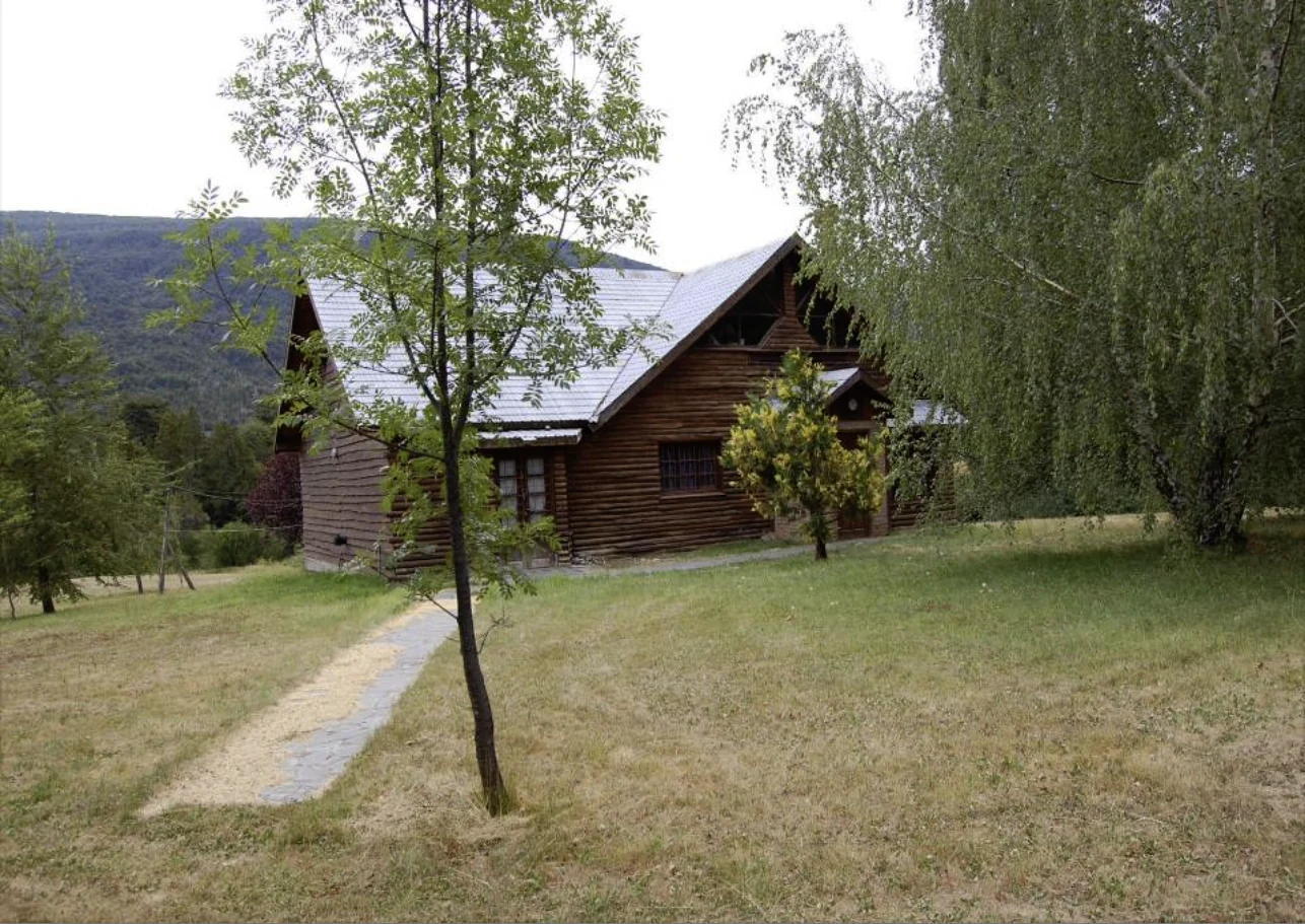Casa principal de ciprés y sendero de piedra entre los árboles