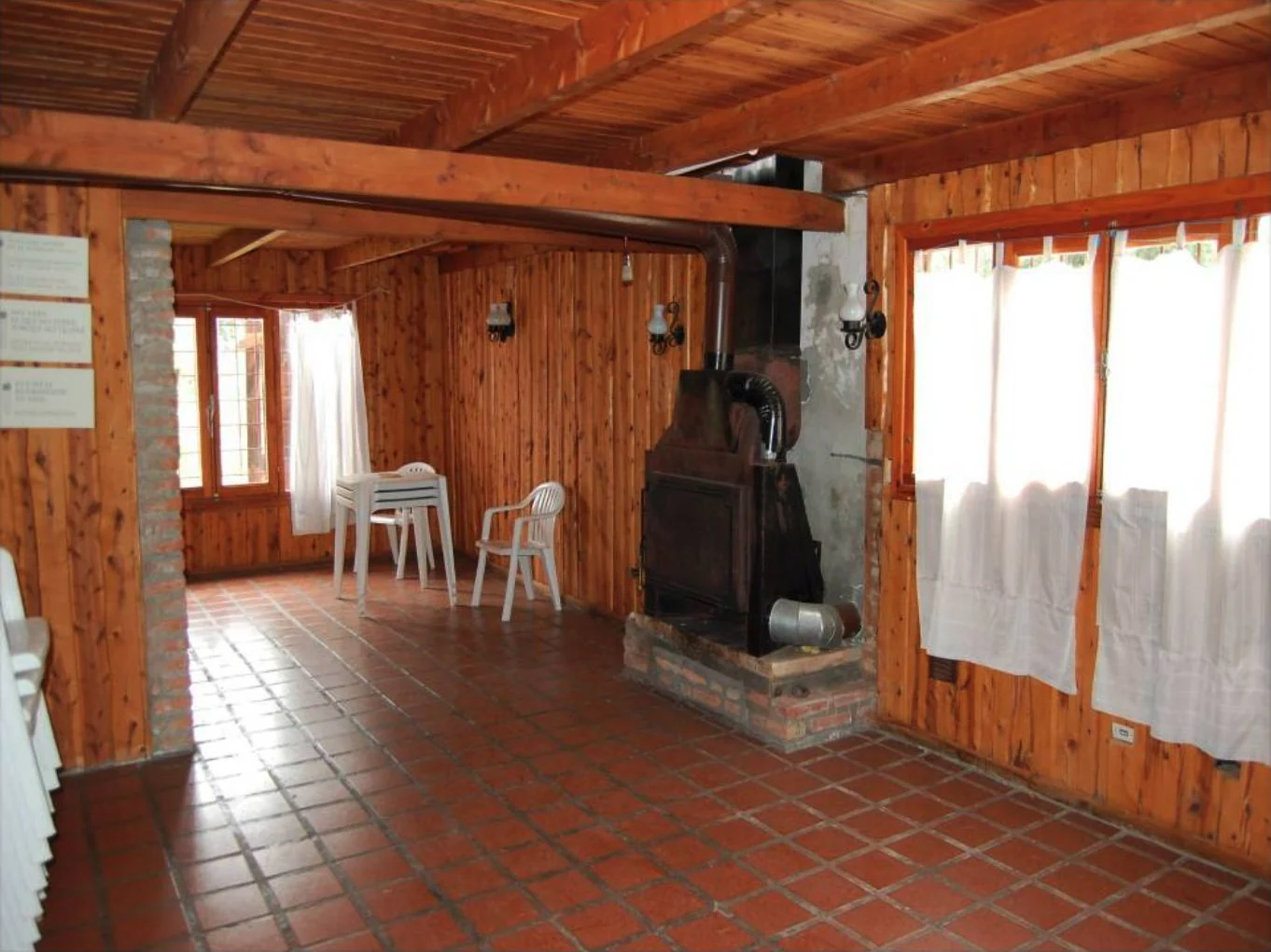 El estar de la casa, con revestimientos de madera y hogar a leña